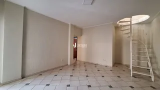 Vista de um corredor interno com piso de cerâmica e escada.