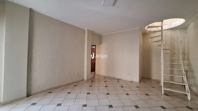 Vista de um corredor interno com piso de cerâmica e escada.