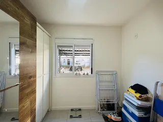 Interior de um cômodo com parede de madeira e janela em uma residência.
