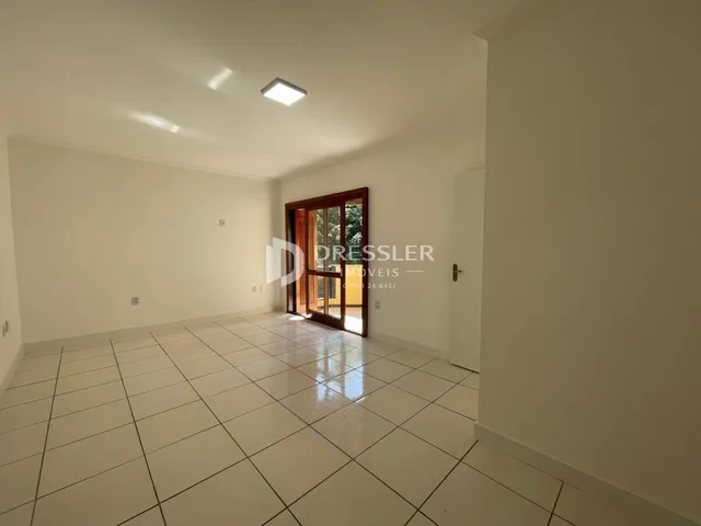 Interior de uma sala com piso de cerâmica e teto branco.
