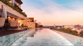 Vista panorâmica de uma área externa com piscina ao pôr do sol.