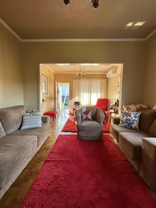 Uma sala de estar com dois sofás e um tapete vermelho.