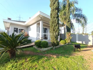 Fachada de uma casa em Lajeado, Brasil com jardim gramado e árvores altas.