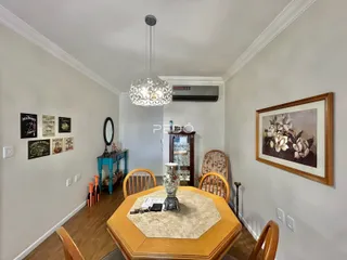 Foto de uma sala de jantar com mesa de madeira e decoração de parede.