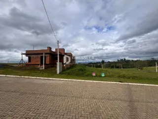 Fachada de uma casa de tijolos em Lajeado com terreno gramado.