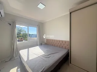 Quarto com janela e cortinas brancas.