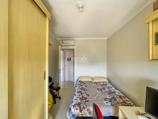 Quarto com cama e porta de madeira em um imóvel no Brasil.