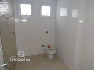 Foto de um banheiro interno com paredes brancas e piso claro.