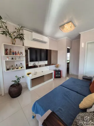 Quarto com cama de casal e televisão montada na parede em um imóvel.