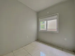 Foto de um cômodo interno com paredes brancas e piso de cerâmica.