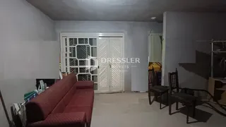 Imagem de uma sala com sofá e portas brancas em um imóvel.
