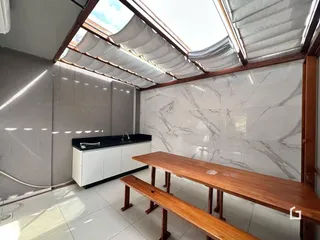 Interior de uma sala com paredes de mármore e mesa de madeira.