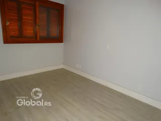 Vista interna de um cômodo com piso de madeira clara.