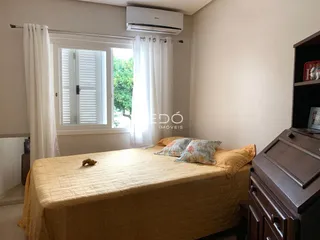 Quarto com janela e cama em ambiente claro.