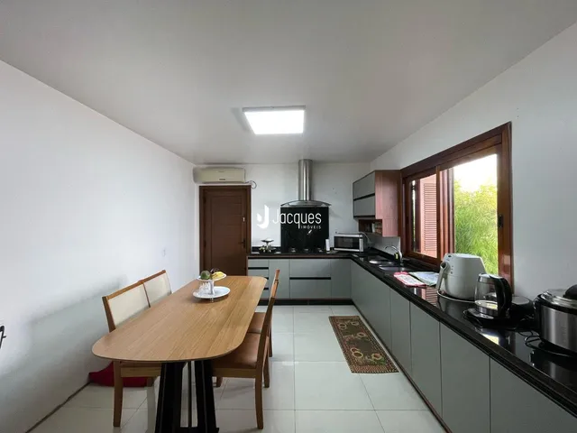 Foto interna de uma sala de jantar com cozinha em um imóvel.