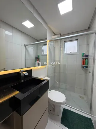 Foto de um banheiro com box de vidro e piso cerâmico.