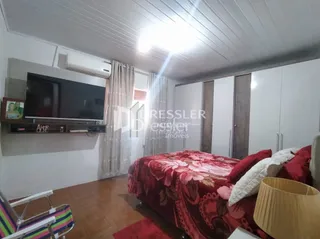 Foto de uma sala de estar com cama e televisão em um imóvel no Brasil.