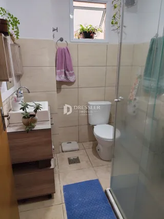 Foto de um banheiro com revestimento cerâmico e louças sanitárias.