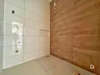 Foto de um corredor com paredes brancas e uma parede de destaque marrom em um imóvel.