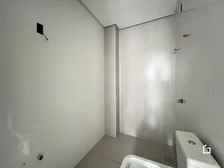 Foto de um banheiro com piso claro e paredes brancas.