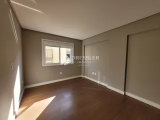 Sala de estar com piso de madeira e janela na parede.