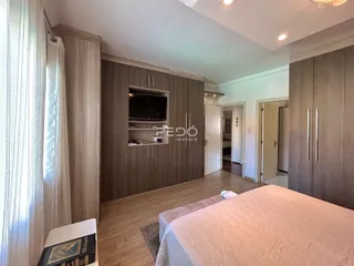Quarto com armários em madeira e cama.