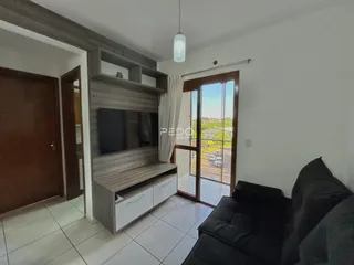Sala de estar com painel de madeira e porta de vidro.