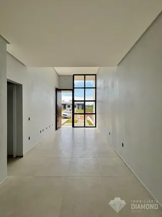 Corredor interno de uma residência com paredes brancas e piso claro.