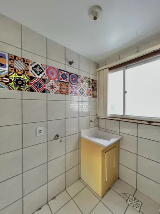 Foto de um banheiro com revestimento cerâmico e janela.