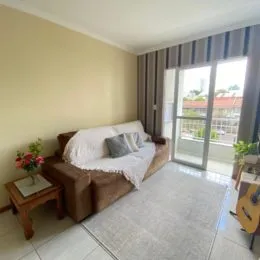 Sala de estar com cama e janela de grande abertura.