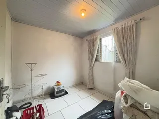Quarto interno com paredes brancas e piso de cerâmica claro.