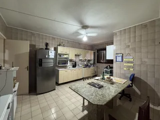 Foto de uma cozinha com armários e bancada de granito em um imóvel no Brasil.