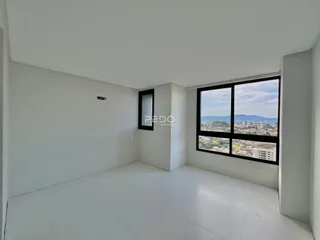 Ambiente interno de uma sala ampla com vista para a paisagem urbana.