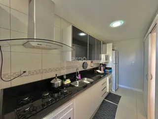 Foto de uma cozinha moderna com armários brancos e bancadas escuras.