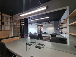 Sala de reunião moderna com mesa de vidro e ambiente de escritório.