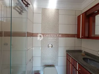 Foto de um banheiro com revestimento de cerâmica e box de vidro.