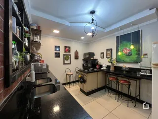 Foto de uma cozinha moderna com bancadas escuras e piso claro.