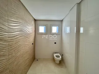 Ambiente interno de um banheiro com paredes texturizadas e piso claro.