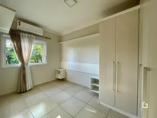 Ambiente interno de uma sala com piso de cerâmica e armários embutidos.