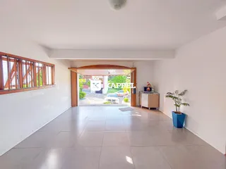 Uma sala de estar clara com piso de cerâmica e uma grande abertura para o exterior.