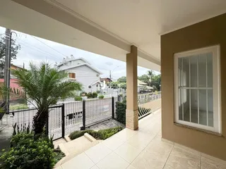 Vista externa de uma propriedade com cerca e vegetação.