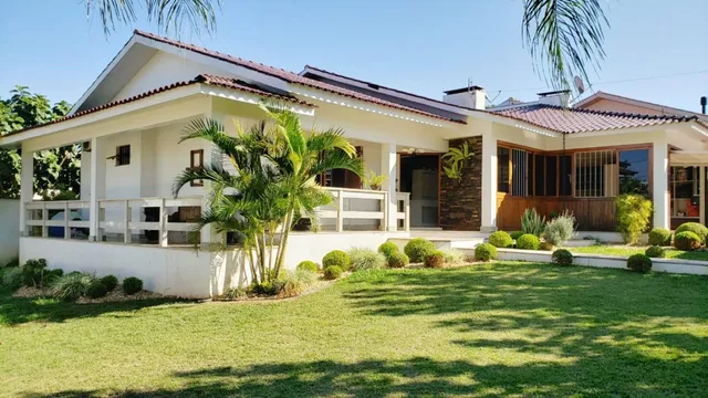 Fachada de uma casa branca com telhado de telhas em Lajeado.