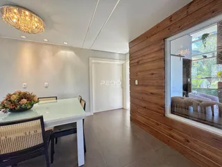 Ambiente interno com mesa de jantar e parede de madeira em um imóvel no Brasil.
