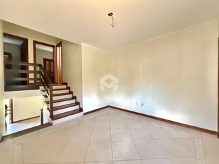 Hall com escadas e piso de cerâmica em uma residência.