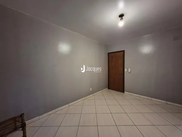 Hall de entrada com piso de cerâmica e parede clara.
