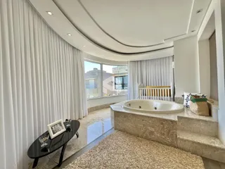 Vista de um banheiro luxuoso com banheira de imersão em mármore.