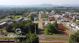 Vista aérea de uma área residencial com terrenos e vegetação no Brasil.