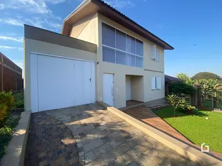 Fachada de uma casa moderna com garagem e jardim em Lajeado, Brasil.