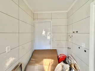 Hall de corredor com paredes brancas e piso de cerâmica.