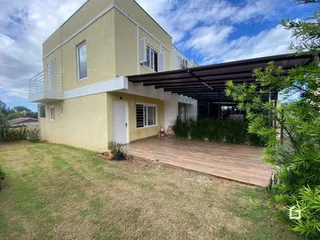 Fachada de uma casa em Lajeado, Brasil com área externa de madeira e gramado.